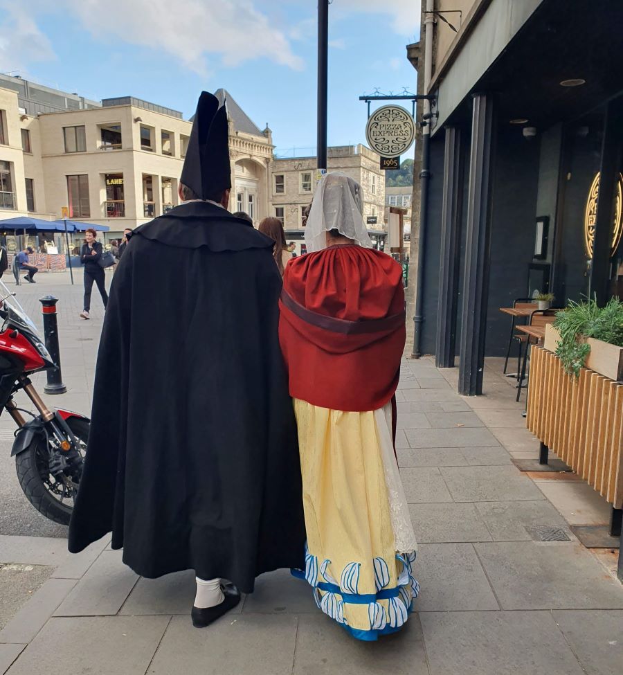 Costumed couple pass Pizza Express